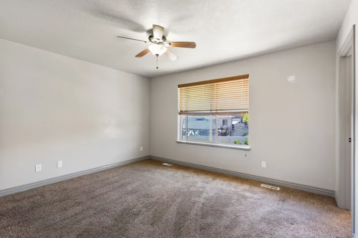 Master bed room with a ceiling fan, a window with horizontal blinds, and light gray wall paint