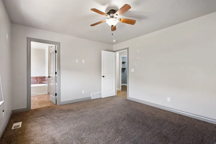 Master bed room with a ceiling fan light fixture