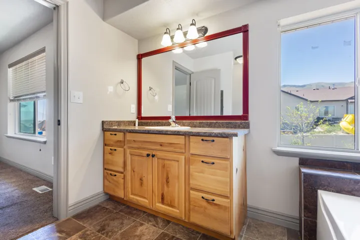 Master Bathroom vanity with natural wood cabinetry and dark hardware