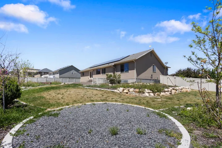 Expansive backyard featuring a terraced landscape, decorative gravel beds, and a full privacy fence