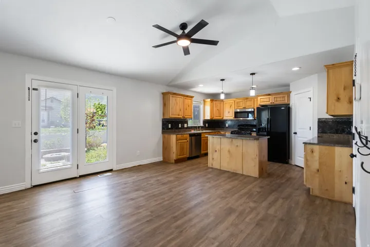 Expansive living area featuring vaulted ceilings, wood-finish flooring, and French doors