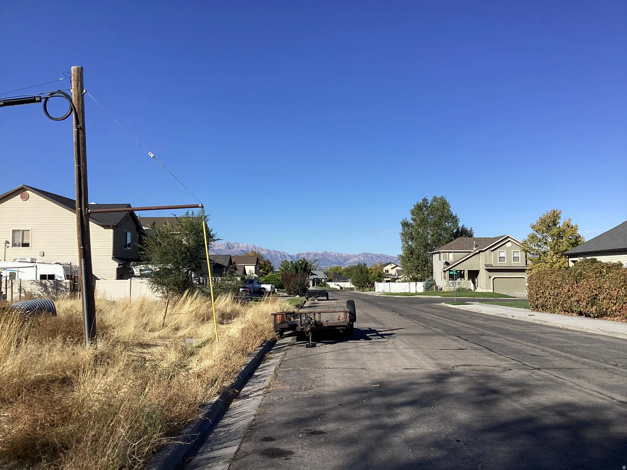 Expansive lot featuring natural ground cover, street frontage, and mountain range scenery