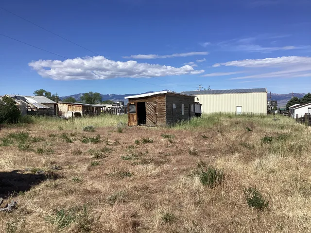 Expansive undeveloped lot featuring dry grass and a clear blue sky