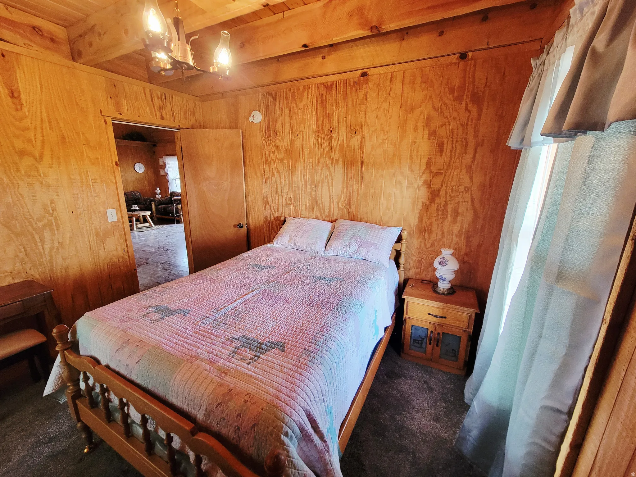 Wood-paneled room featuring exposed ceiling beams and recessed lighting