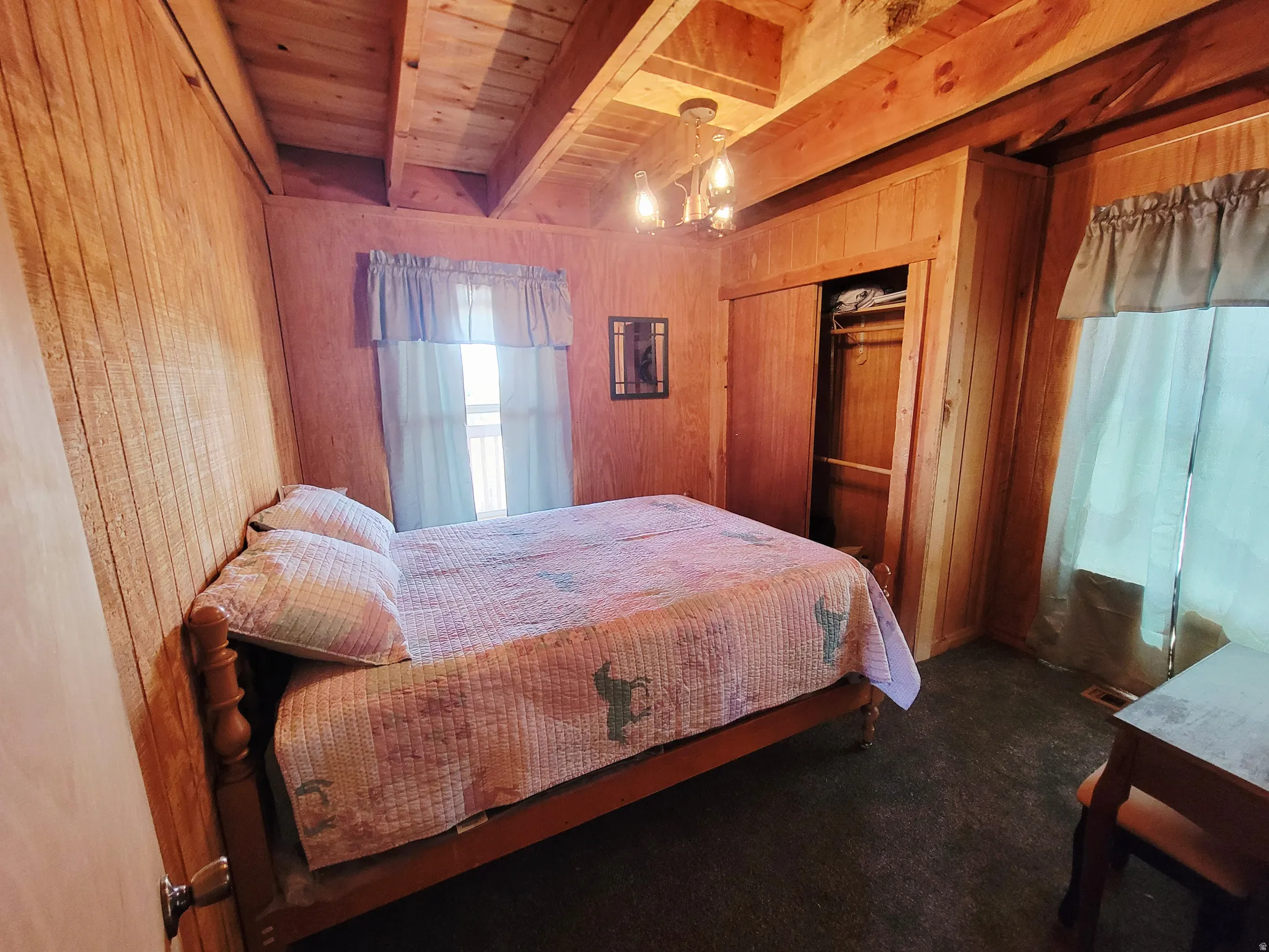 Interior room featuring wood-finish walls and a wood-finish vaulted ceiling with exposed beams