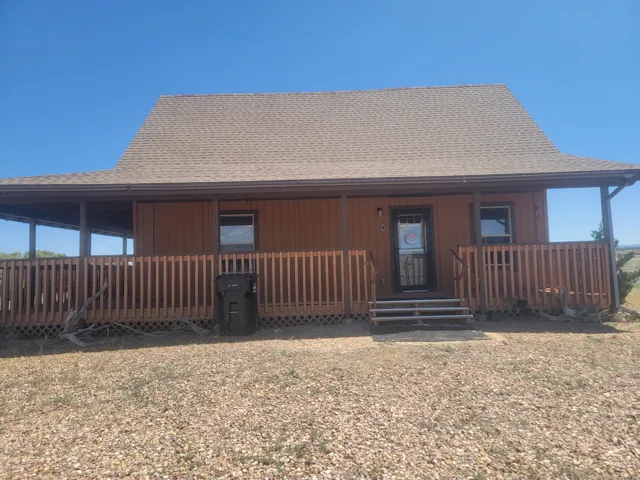Property exterior featuring a full-width covered porch with wood railing