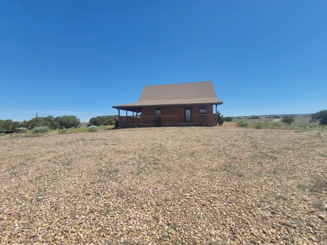 Wood-sided cabin-style residence featuring a covered front porch with railings