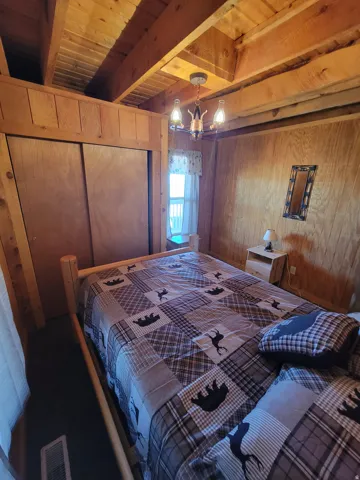Room featuring exposed wood beam ceilings and wood-paneled walls