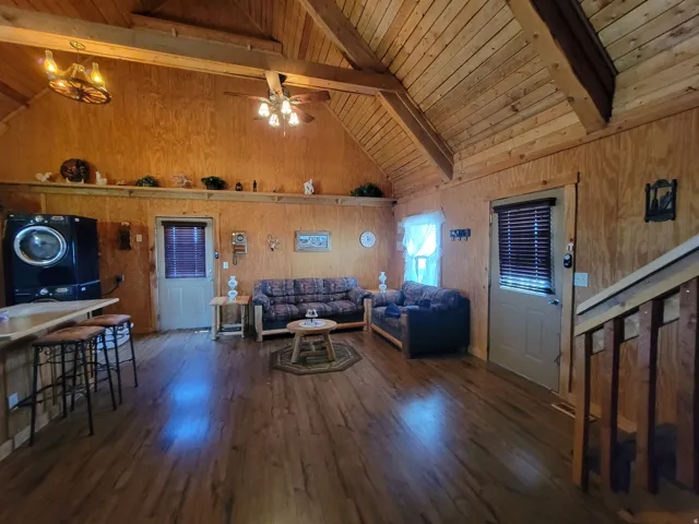 Vaulted wood-paneled ceilings with exposed beams, wood-finish flooring, and two interior doors