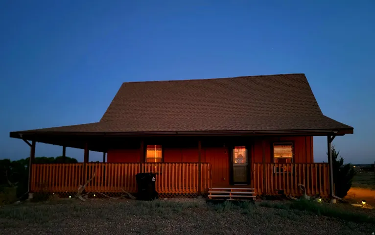 Single-story home featuring a covered porch with wood railing and steps