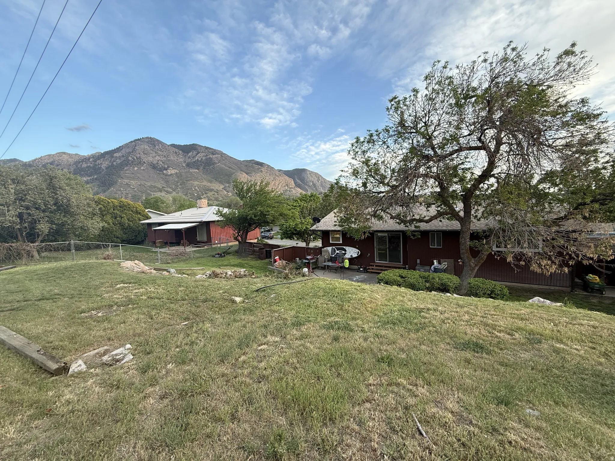 Expansive property featuring a sloped lawn and mature trees