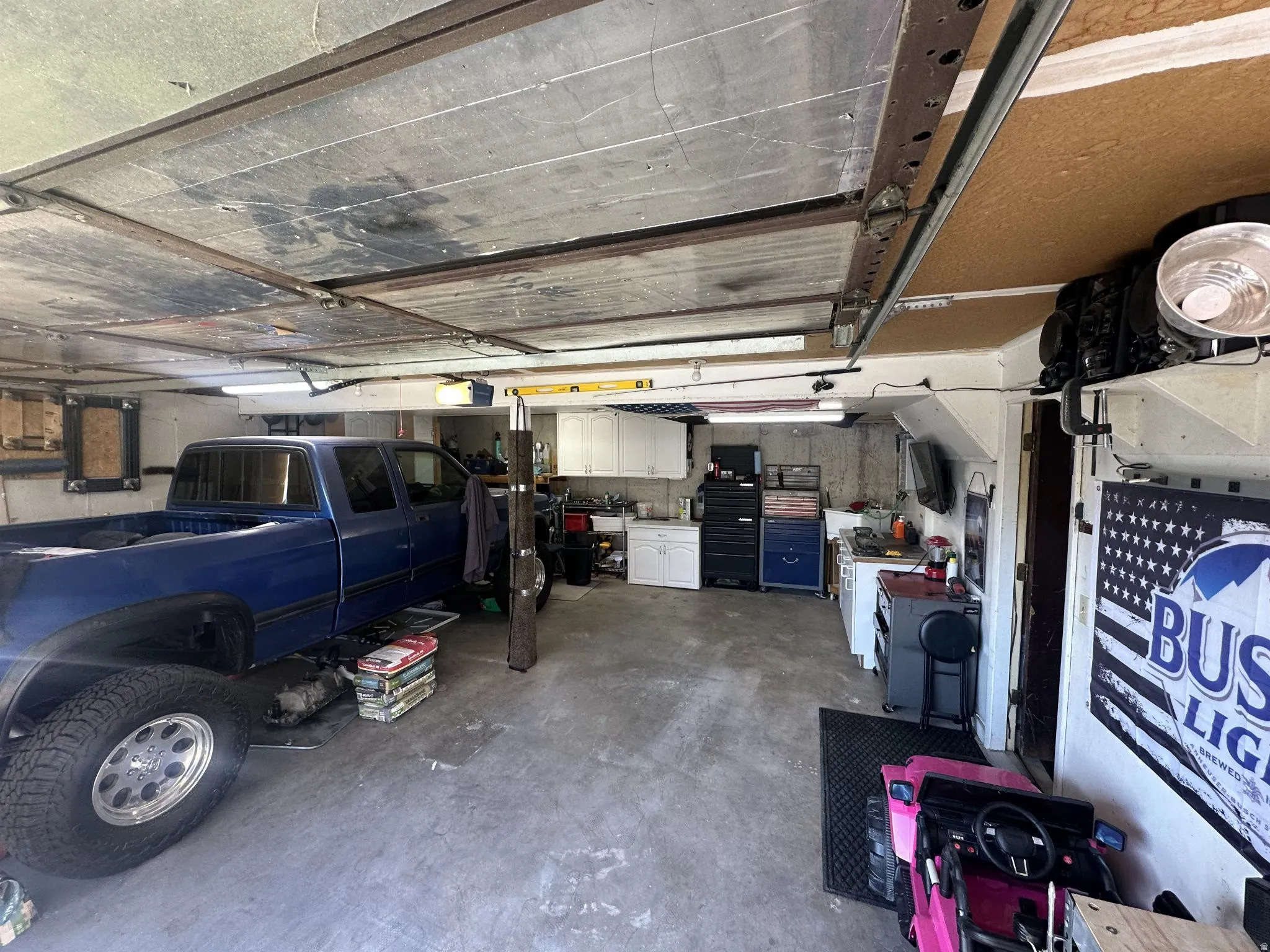 Spacious garage featuring a concrete floor, exposed ceiling joists, and track lighting