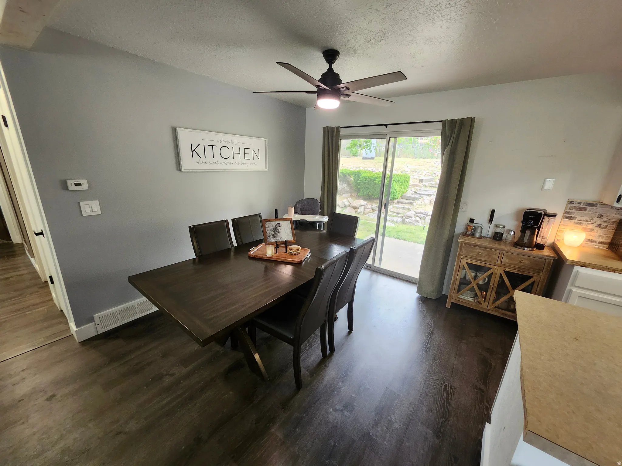 Dining area with wood-finish flooring and a ceiling fan with integrated lighting