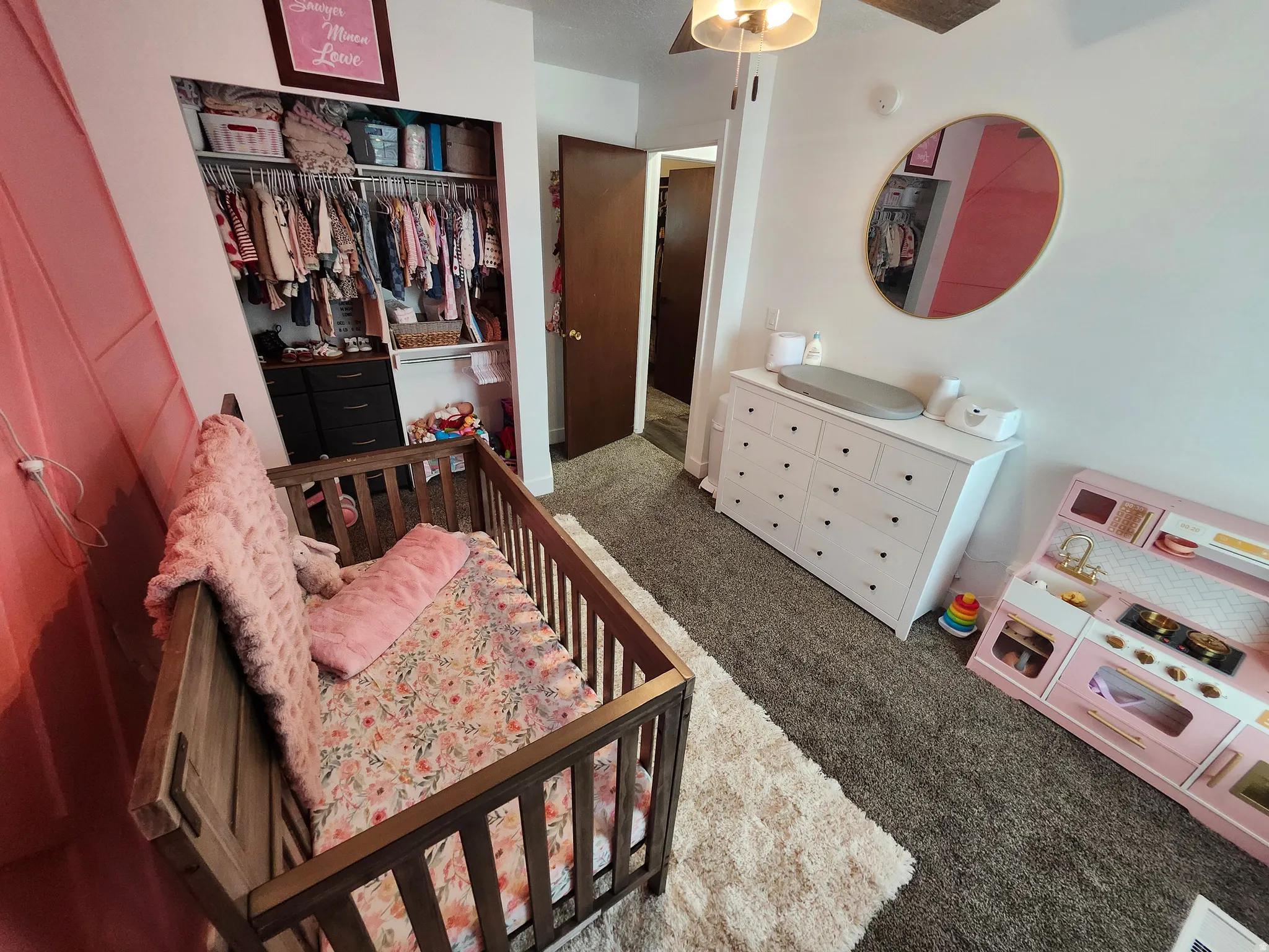 Carpeted room featuring a built-in closet with shelving and hanging rods