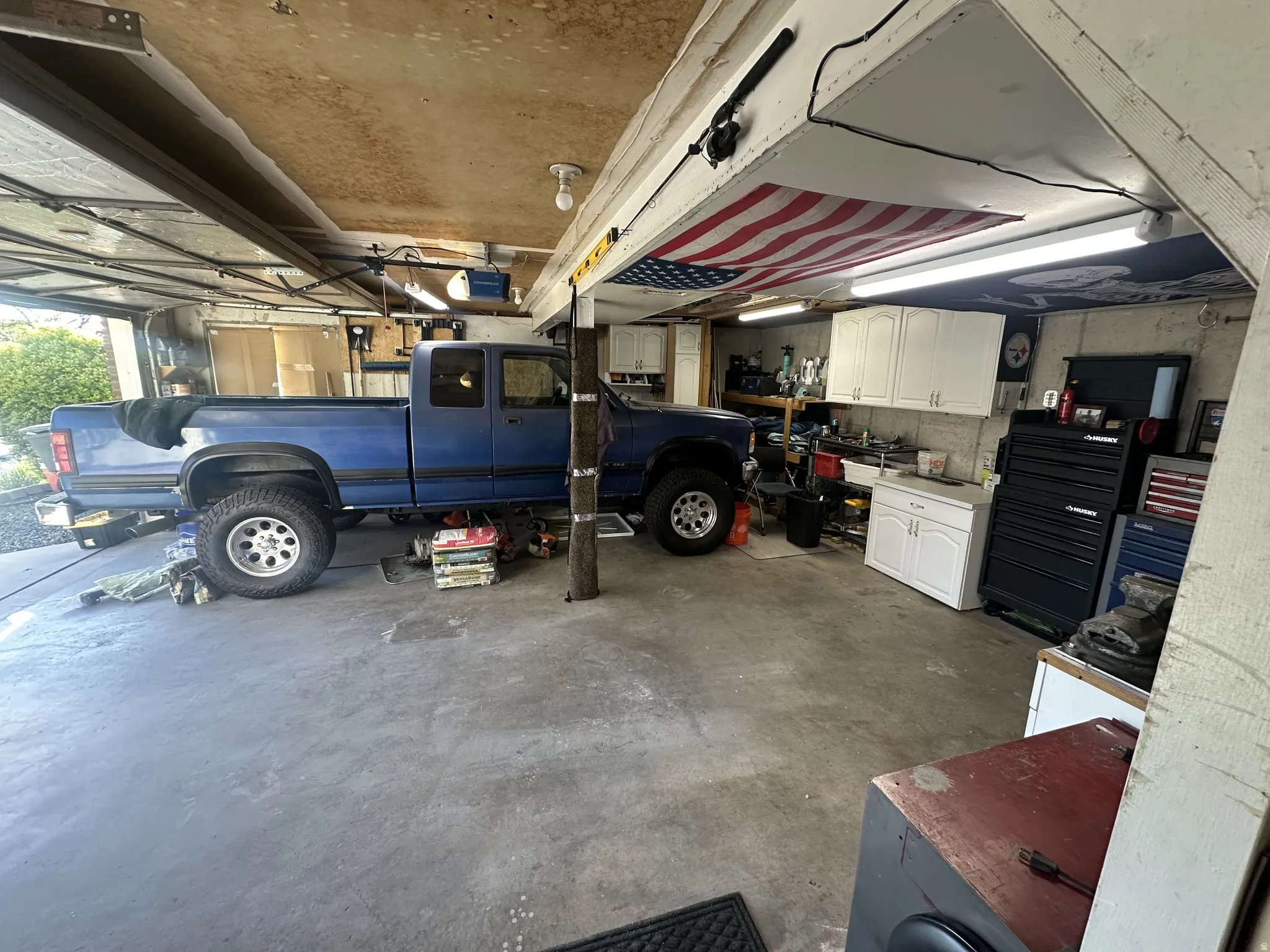 Spacious garage featuring a concrete floor, built-in cabinetry, and overhead lighting