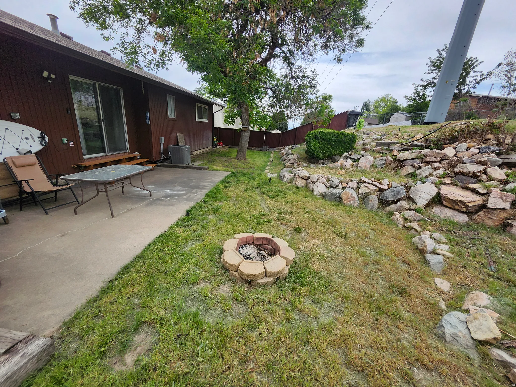 Rear concrete patio offering outdoor living space and fire pit