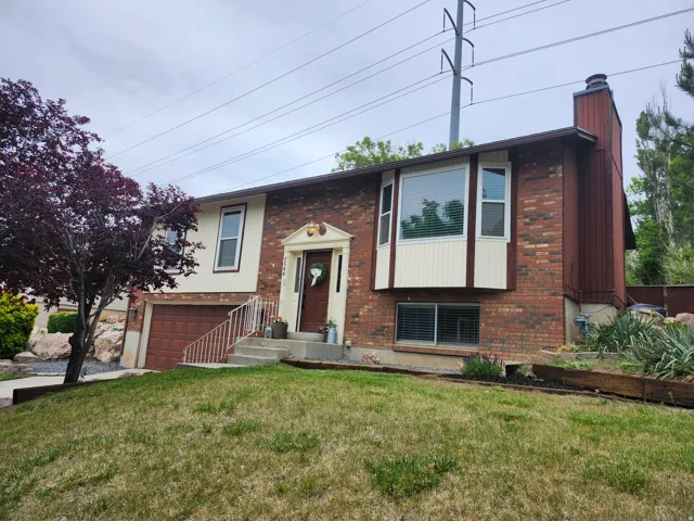 Brick and siding exterior featuring a prominent bay window with blinds