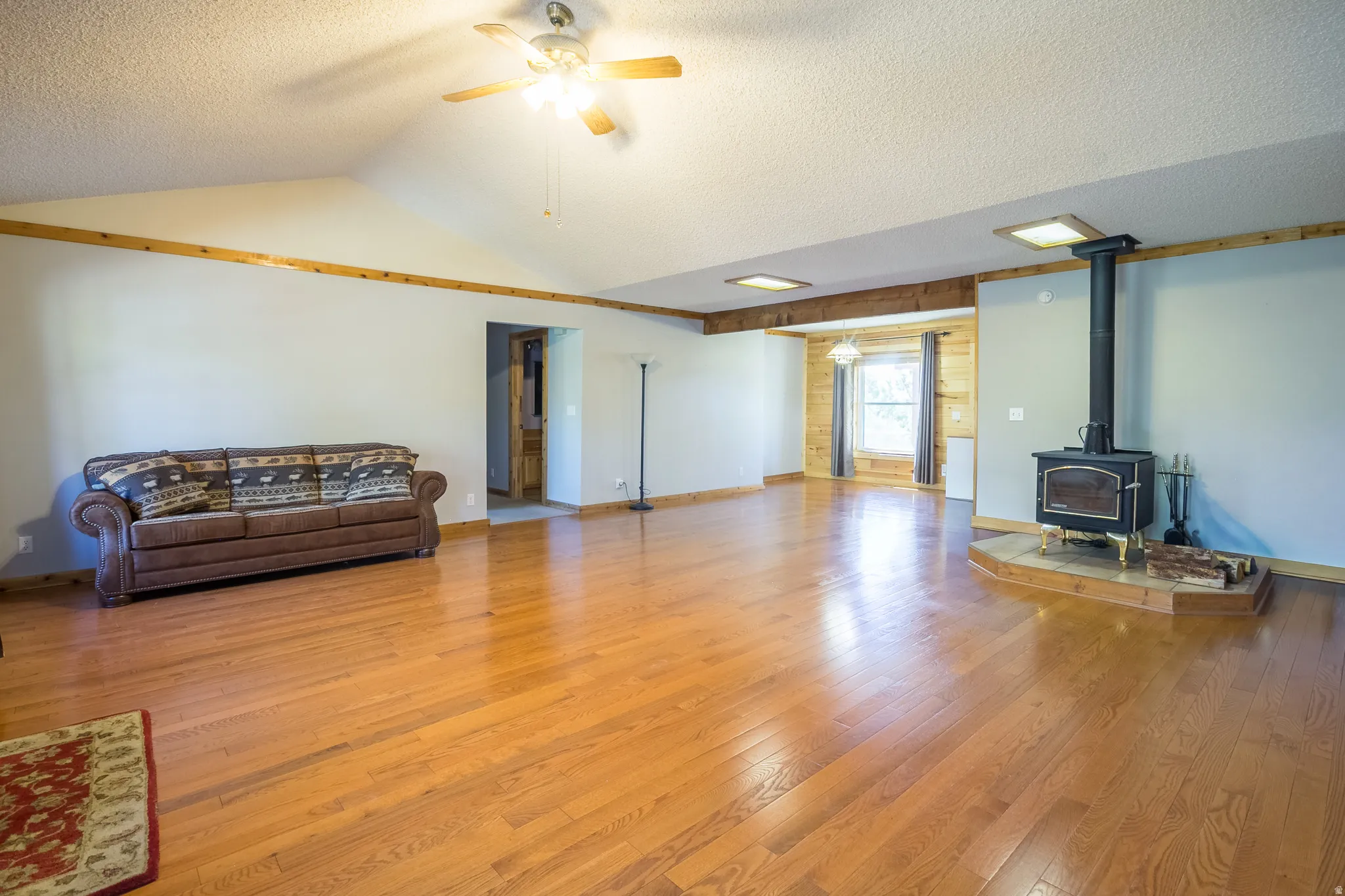 Vaulted ceiling with wood trim accents and a ceiling fan