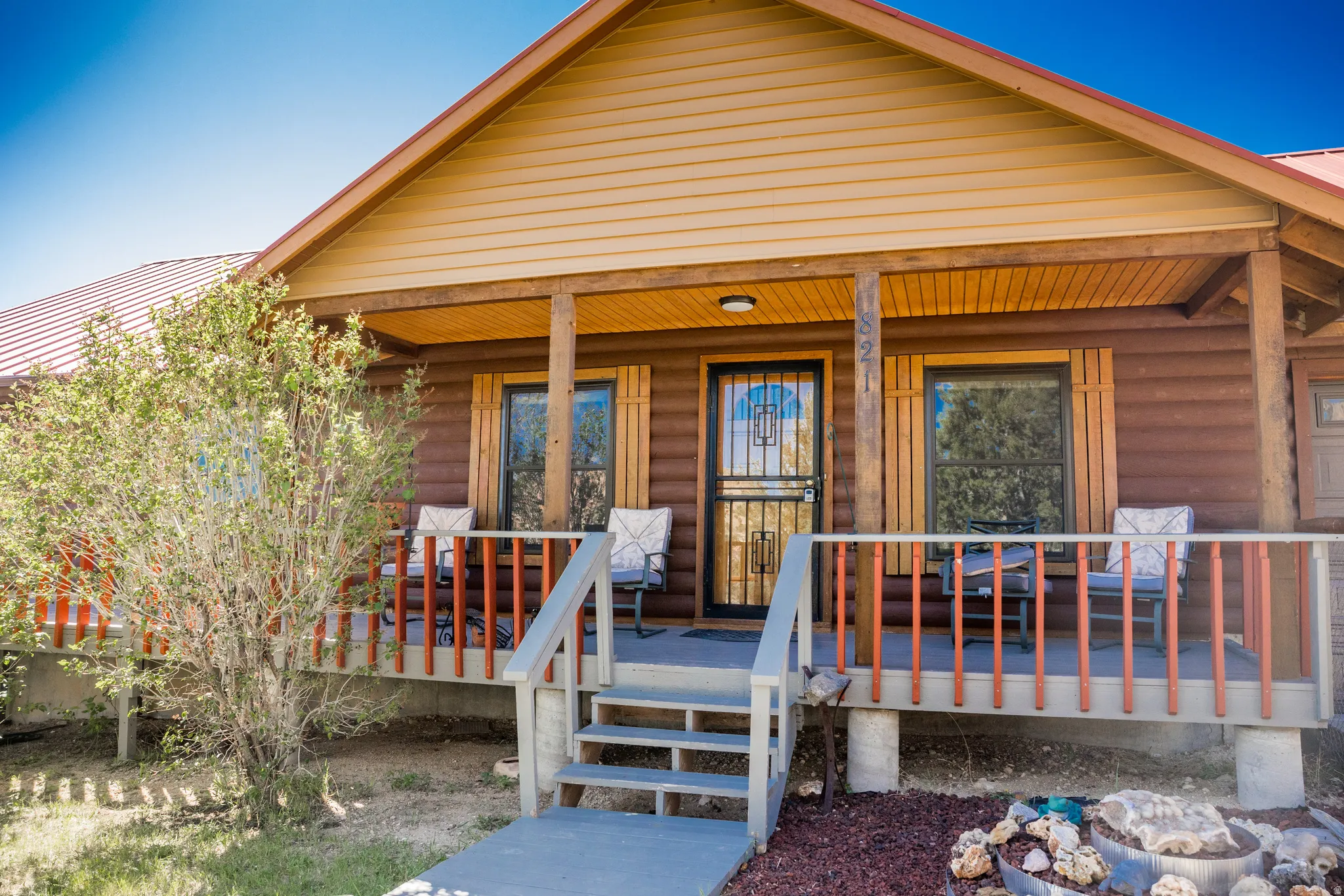 Inviting front porch featuring a metal roof, wood-look siding, and a security screen door