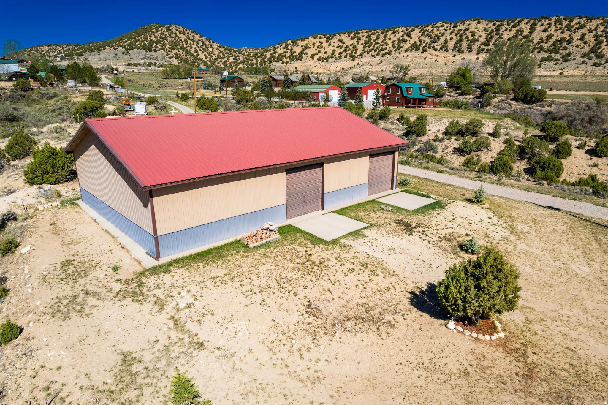 Large utility building featuring a red metal roof and two tone siding