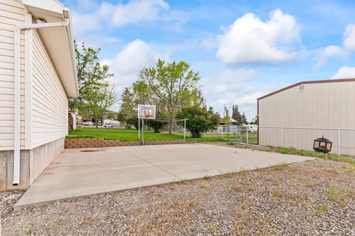 Concrete patio area featuring a basketball hoop