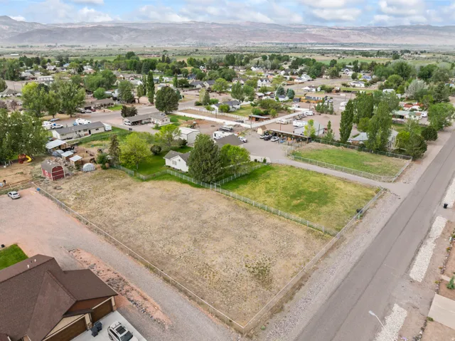 Expansive, fenced land parcels with a gravel road bordering one side