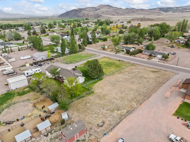 Expansive property featuring a ranch-style residence with a dark roof and a rear deck