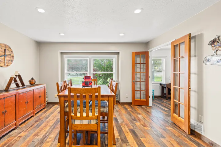 Wood-finish flooring throughout, recessed lighting, and a large window with white blinds