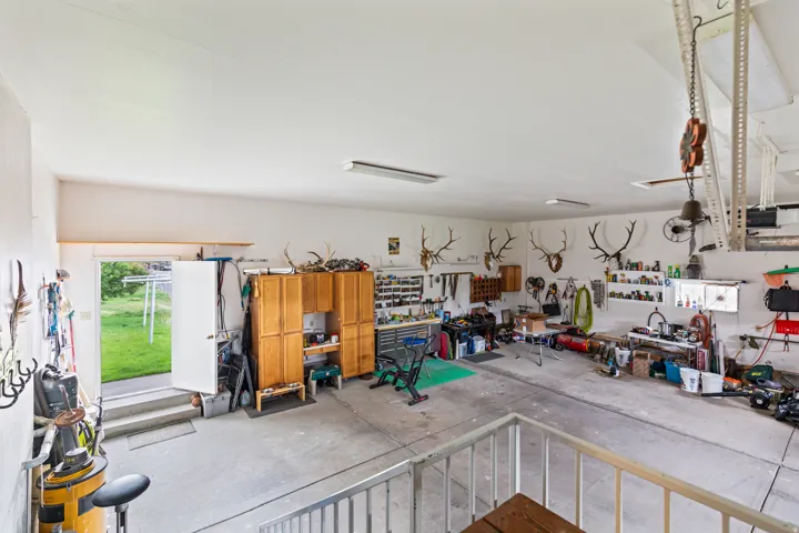 Spacious garage with high ceilings, multiple linear light fixtures, and a concrete floor