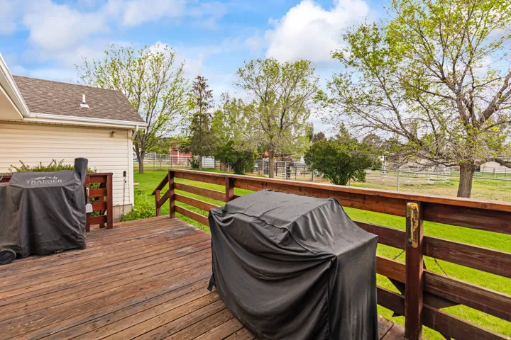 Spacious wood-finish deck with a robust wood railing, providing an open outdoor extension