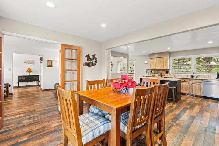 Open-concept living space featuring wood-finish flooring, recessed lighting, and a kitchen with light wood cabinetry