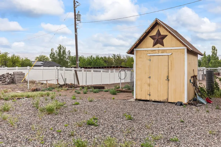 Freestanding wood-paneled shed with a pitched roof and double doors