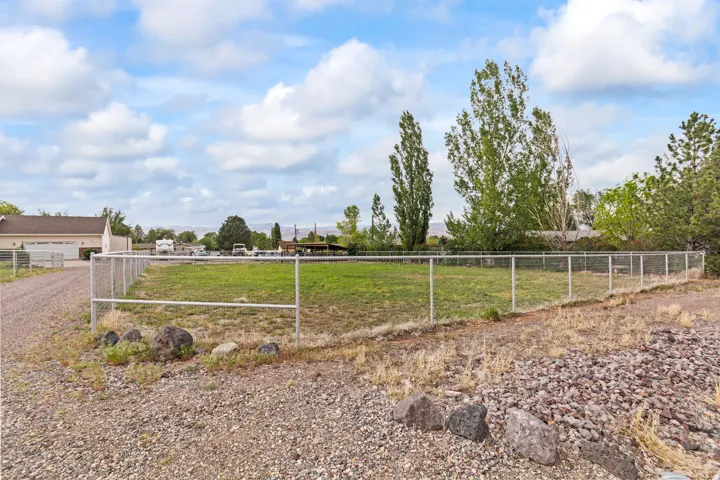 Expansive fenced lot with partial gravel and grass landscaping