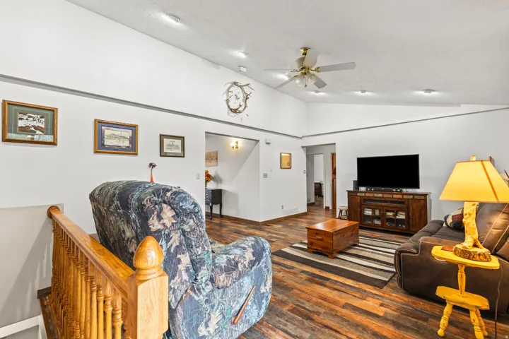 Spacious living area featuring high vaulted ceilings, recessed lighting, wood-finish flooring, and a ceiling fan