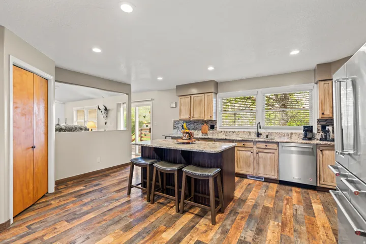 Kitchen featuring wood-finish flooring, recessed lighting, and a center island with counter seating