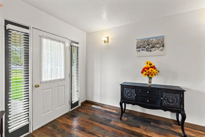 Entryway featuring wood-finish flooring, white walls, and a white entry door with frosted glass