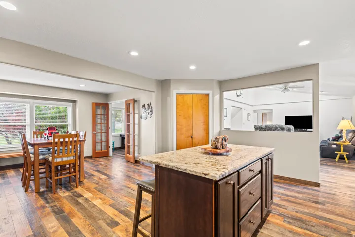 Kitchen island featuring a granite countertop and dark wood cabinetry