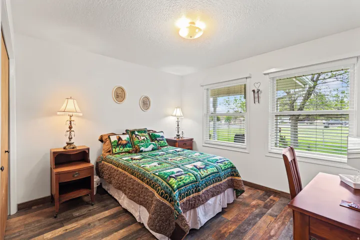 Spacious room featuring wood-finish flooring, white walls, and a ceiling light fixture