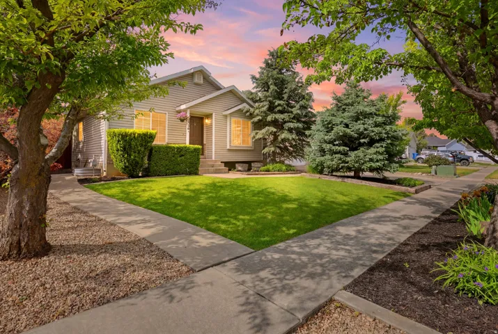 Siding exterior with mature trees, manicured lawn, and concrete walkways