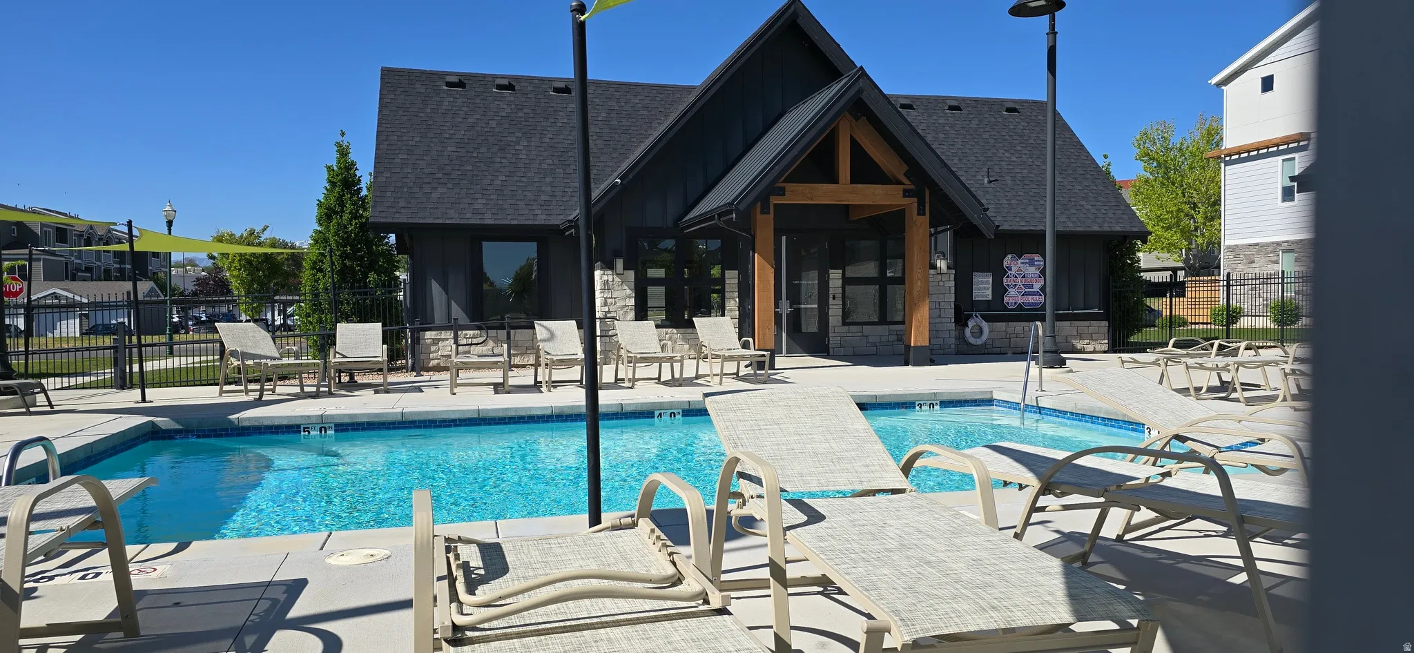 Outdoor swimming pool with integrated spa and surrounding lounge seating