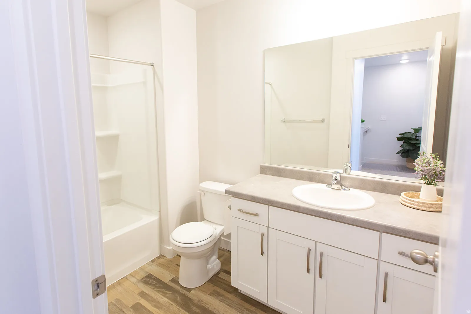 Bathroom featuring a white vanity with brushed nickel hardware, an integrated sink, and a large wall mirror