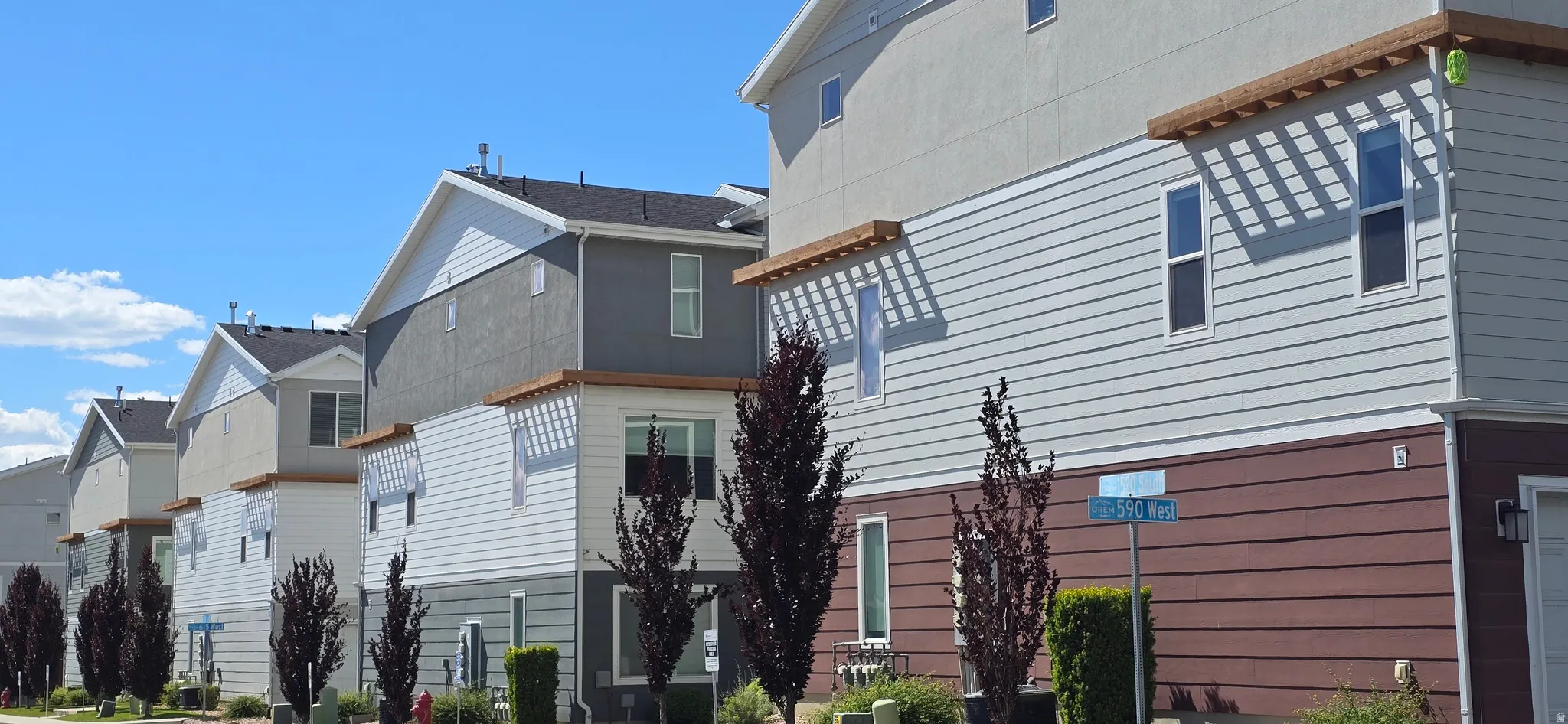 Contemporary townhome-style residences featuring multi-level architecture, varied siding materials, and decorative wooden elements