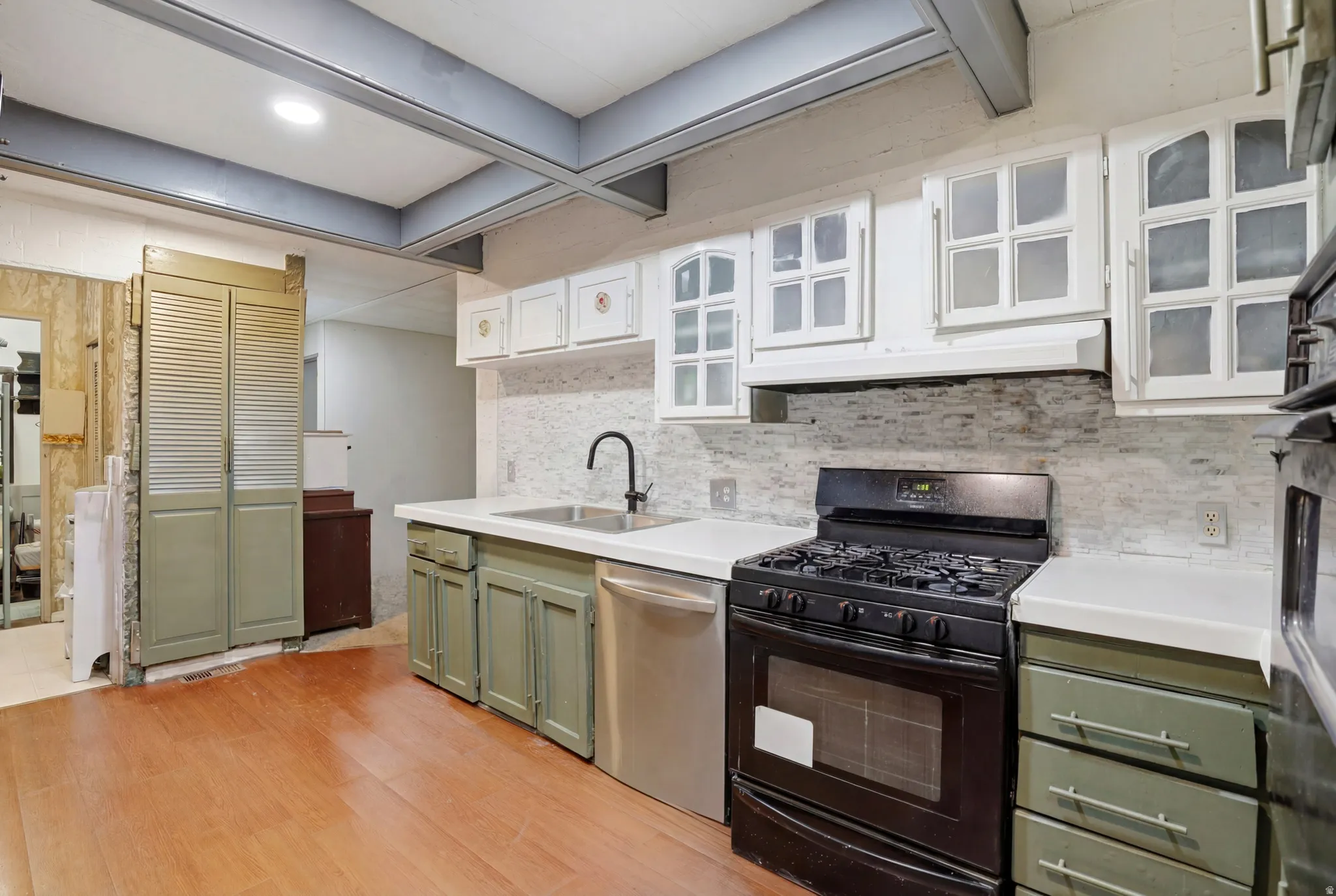 Kitchen featuring light wood-finish flooring, white countertops, and a full stainless steel appliance suite