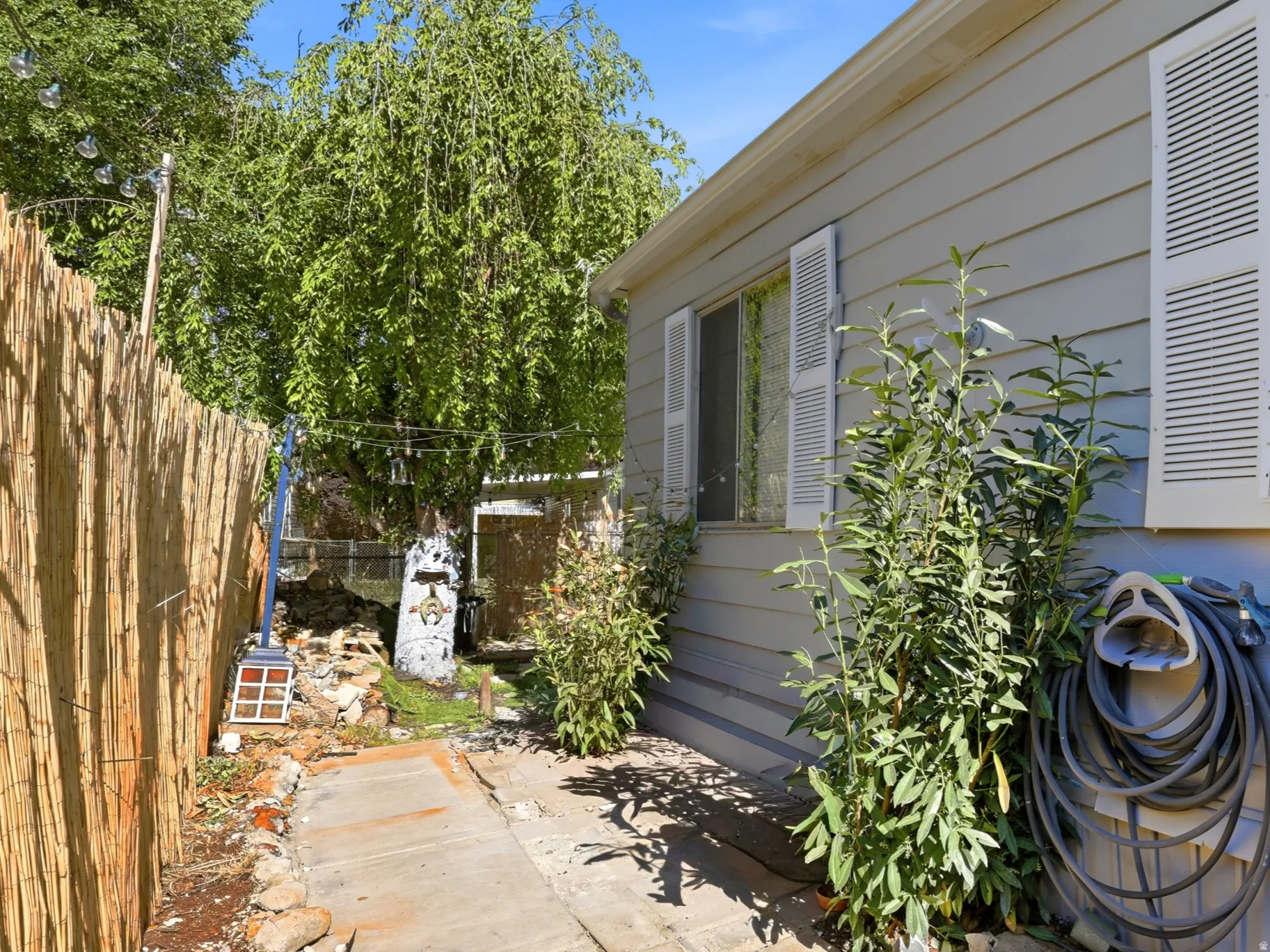 Exterior siding with a window featuring louvered shutters