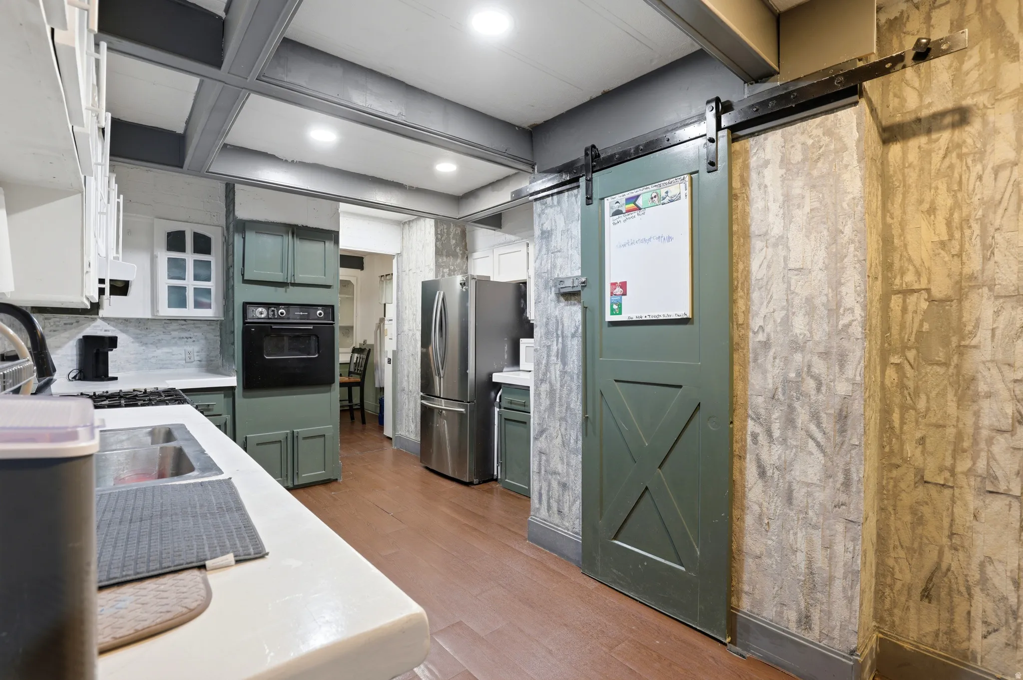 Kitchen featuring wood-finish flooring, recessed lighting, and a green barn door