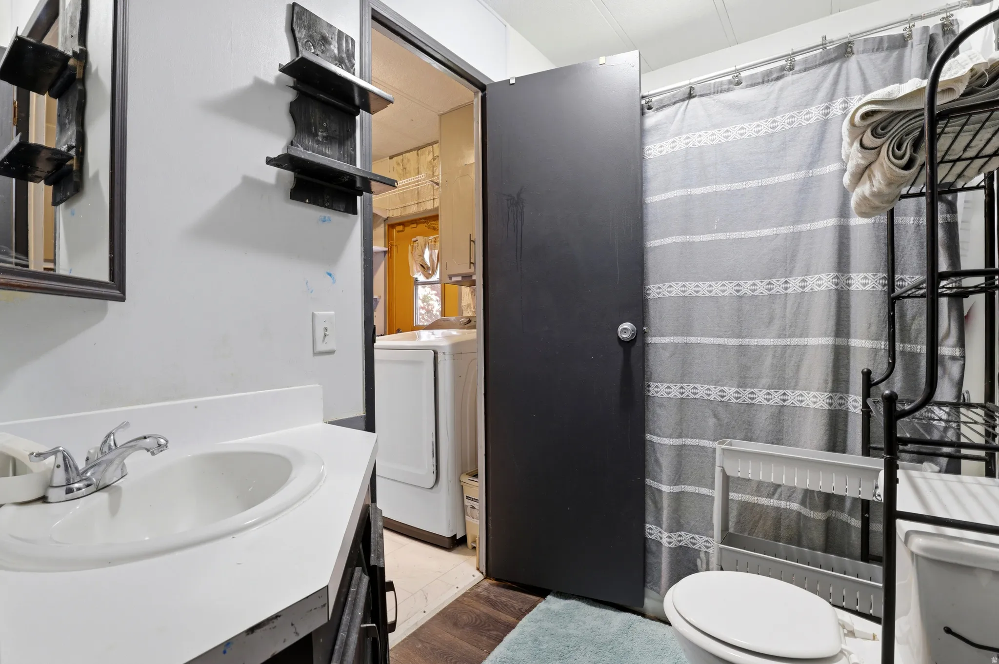 Bathroom featuring a white sink basin, chrome faucet, and dark wood-finish vanity