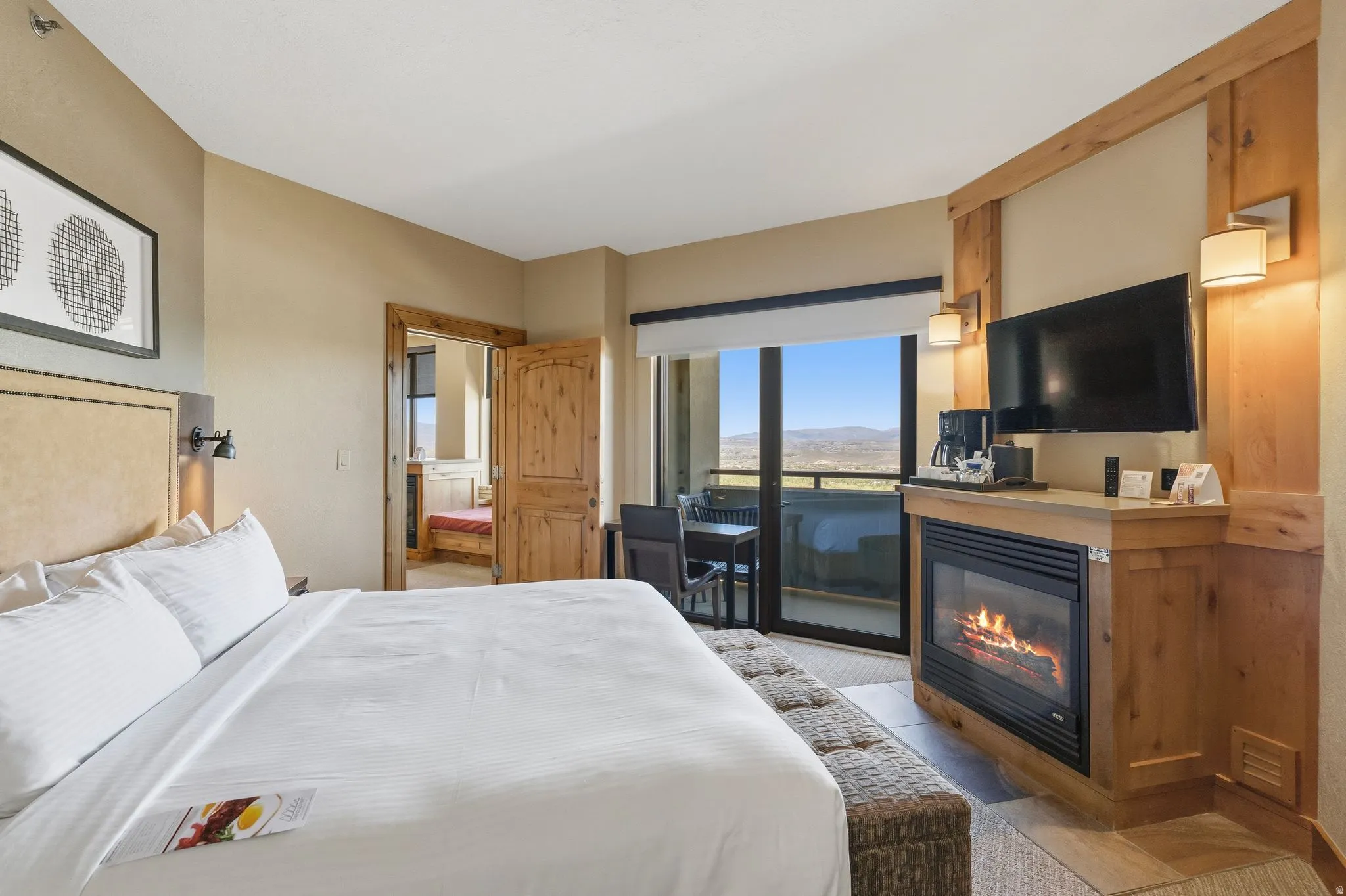 Bedroom featuring a built-in fireplace with a stone hearth, wood-finish mantel, and integrated television