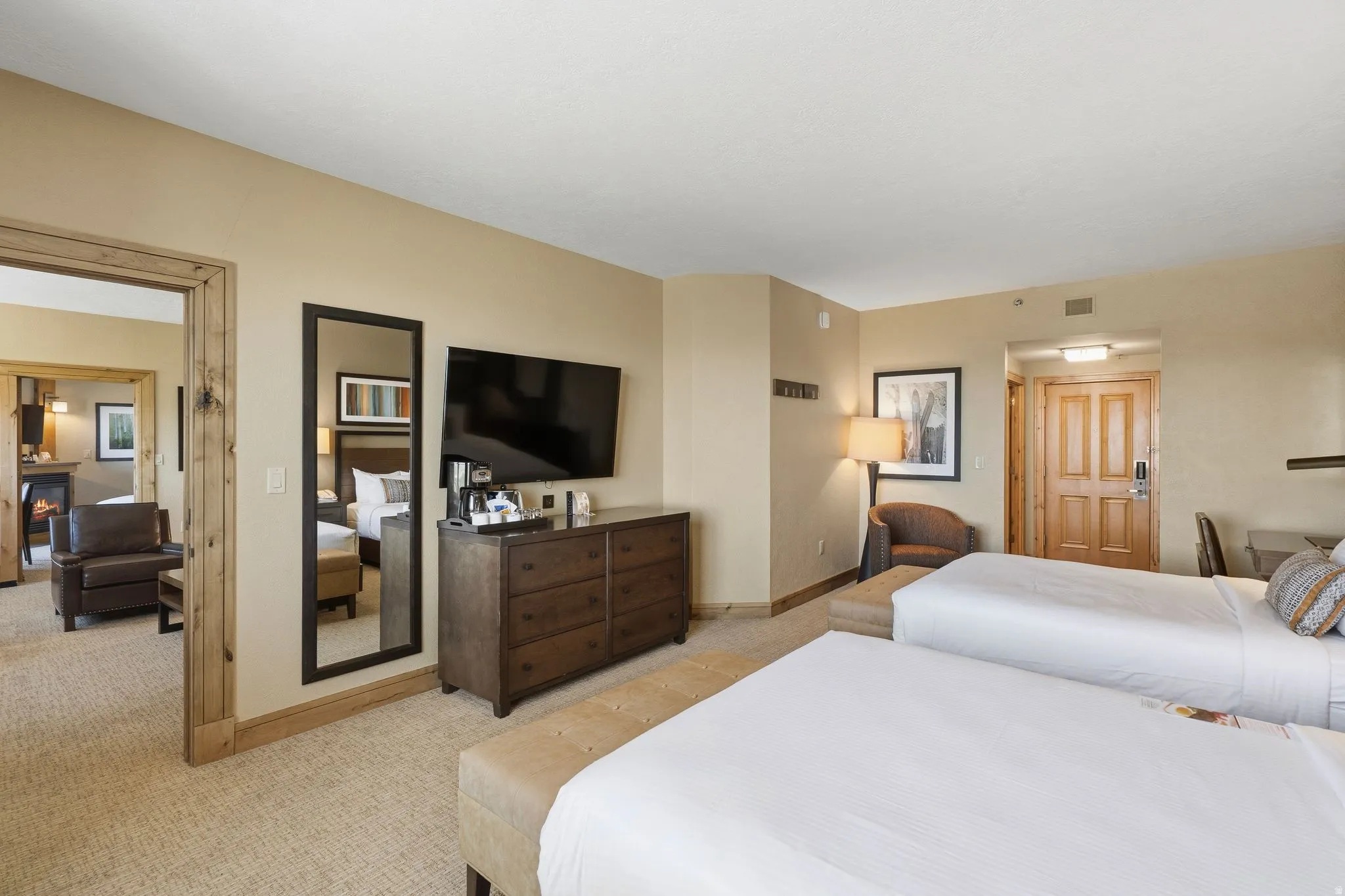 Carpeted bedroom with a built-in entertainment console, a wall-mounted television, and a full-length mirror