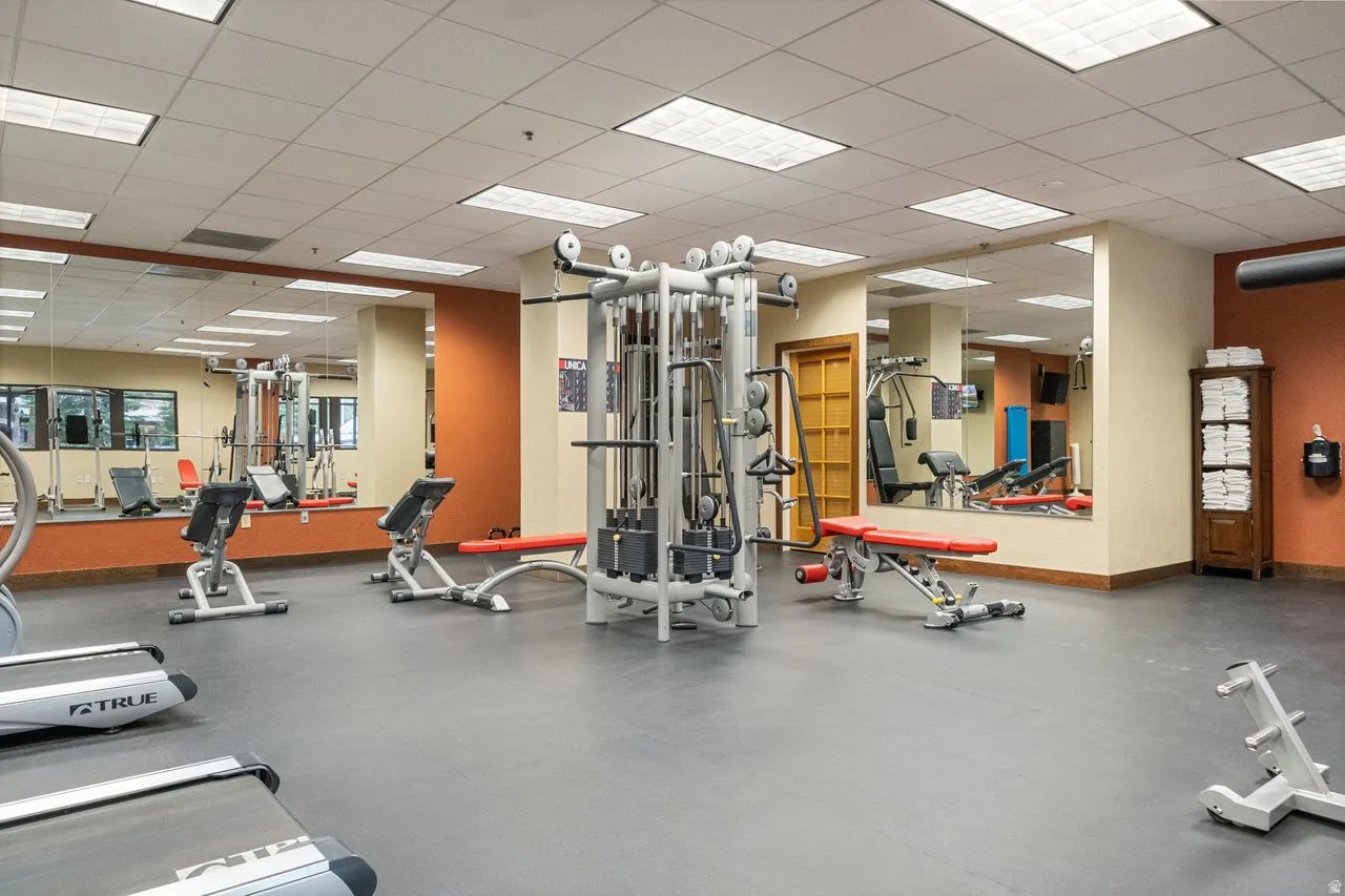 Fitness area featuring padded flooring and mirrored walls