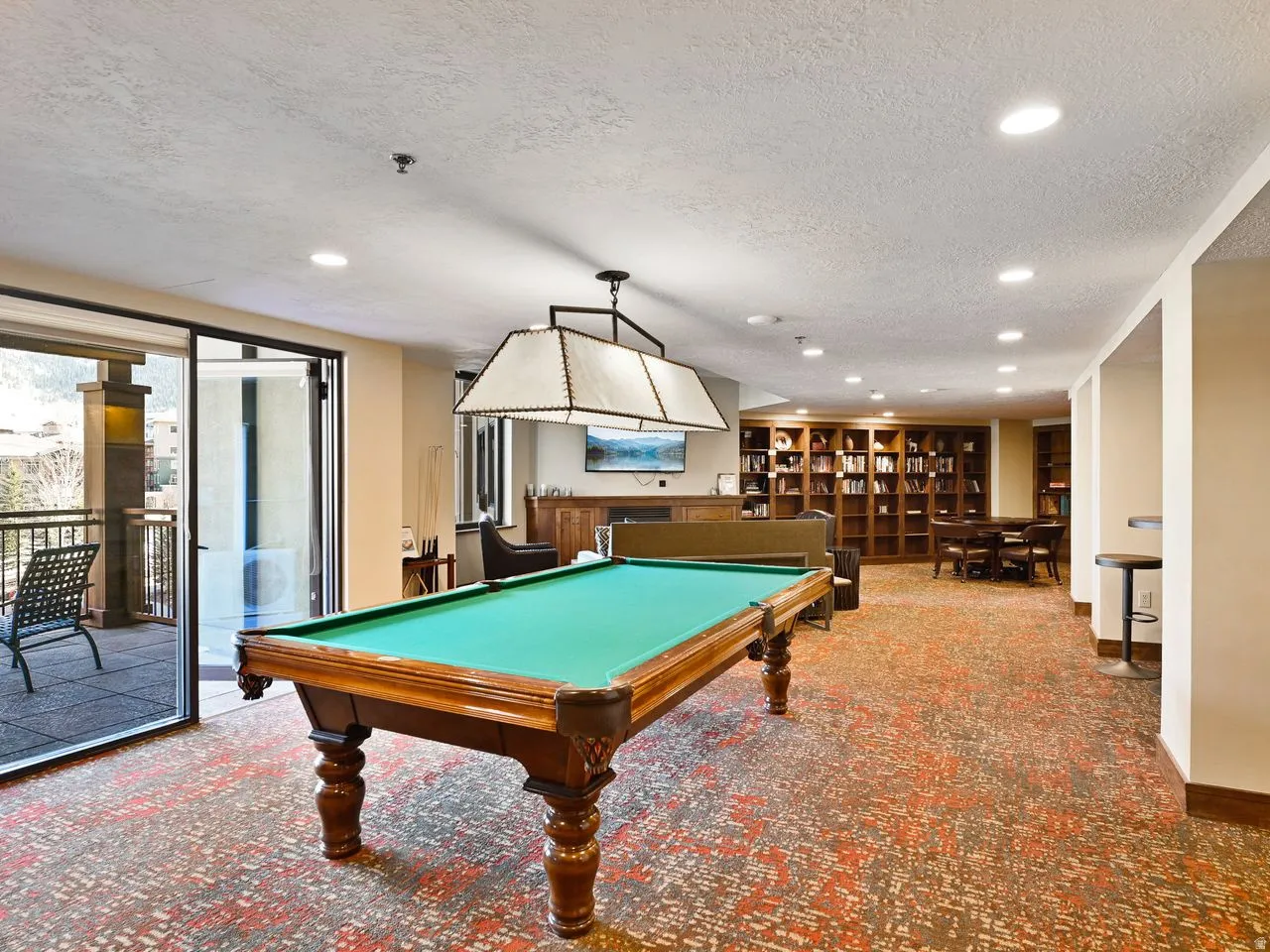 Recreational space featuring a billiards table, patterned carpet, recessed lighting, and a large windowed door opening to a private balcony